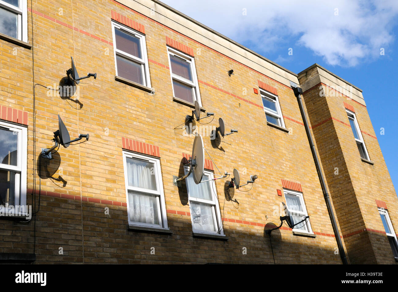 Antennes satellites connectés à un bloc d'appartements, East London, UK Banque D'Images