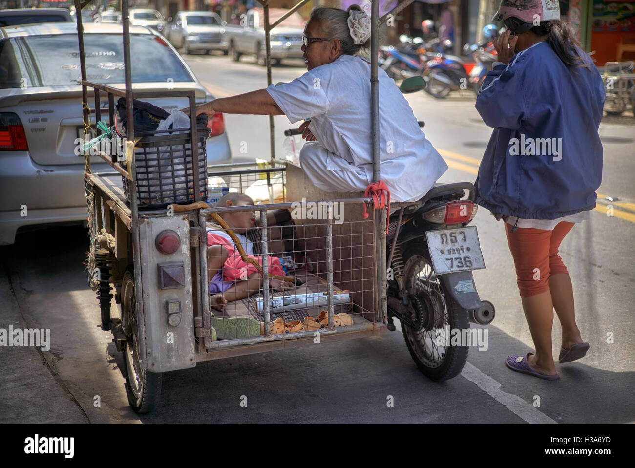 Transport familial en moto en Thaïlande avec bébé endormi en side-car avec mère et grand-mère présents. Thaïlande S. E. Asie Banque D'Images