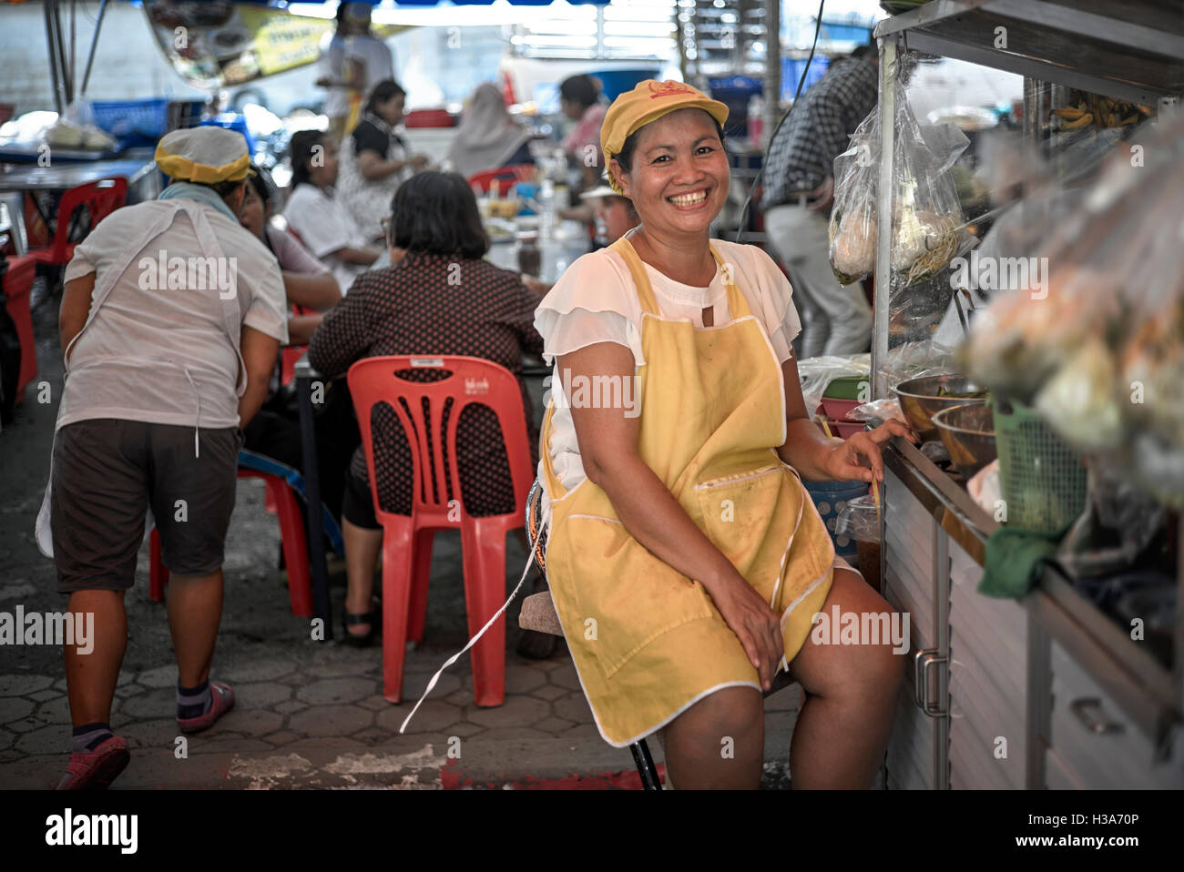 Thaïlande sourire. Un sourire heureux et femelle thaï food vendor à son échoppe de marché. Thaïlande S. E. l'Asie. Asian woman smiling Banque D'Images