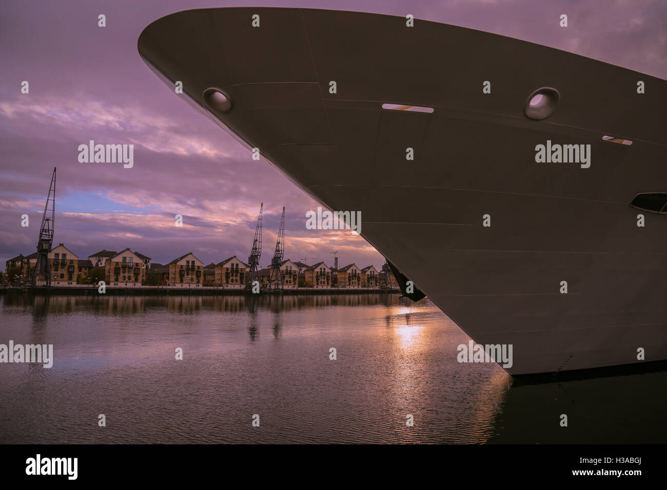 Vue de la coque d'un navire avec un coucher de soleil sur les maisons et de forage dans l'arrière-plan de Canning Town, une partie industrielle de l'Est de Londres. Banque D'Images