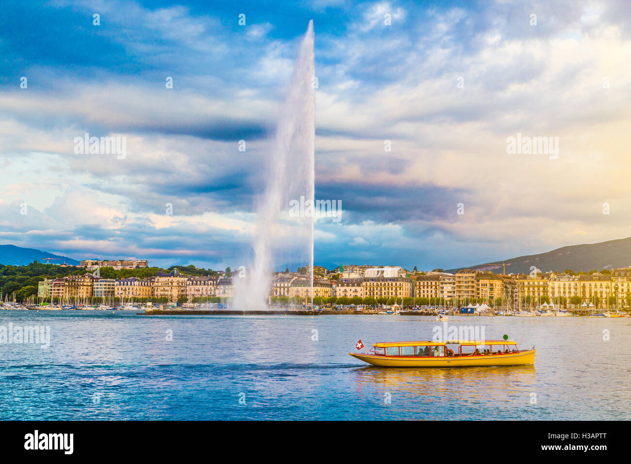 La vue classique du skyline de Genève avec le célèbre Jet d'eau au lac de Genève en belle lumière du soir au coucher du soleil, Suisse Banque D'Images