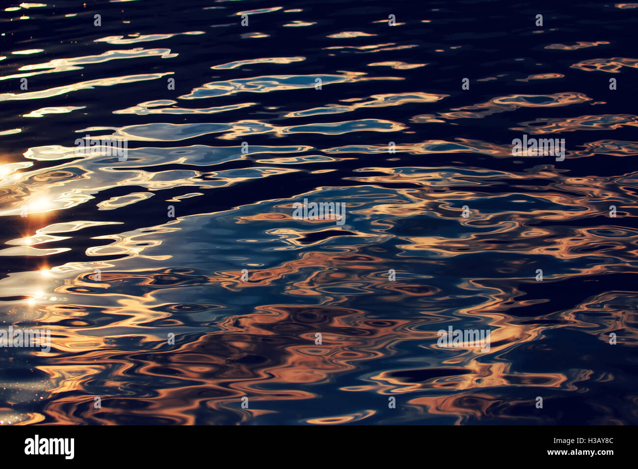Surface de l'eau avec des ondulations dans le coucher du soleil comme abstract nature et environnement Banque D'Images