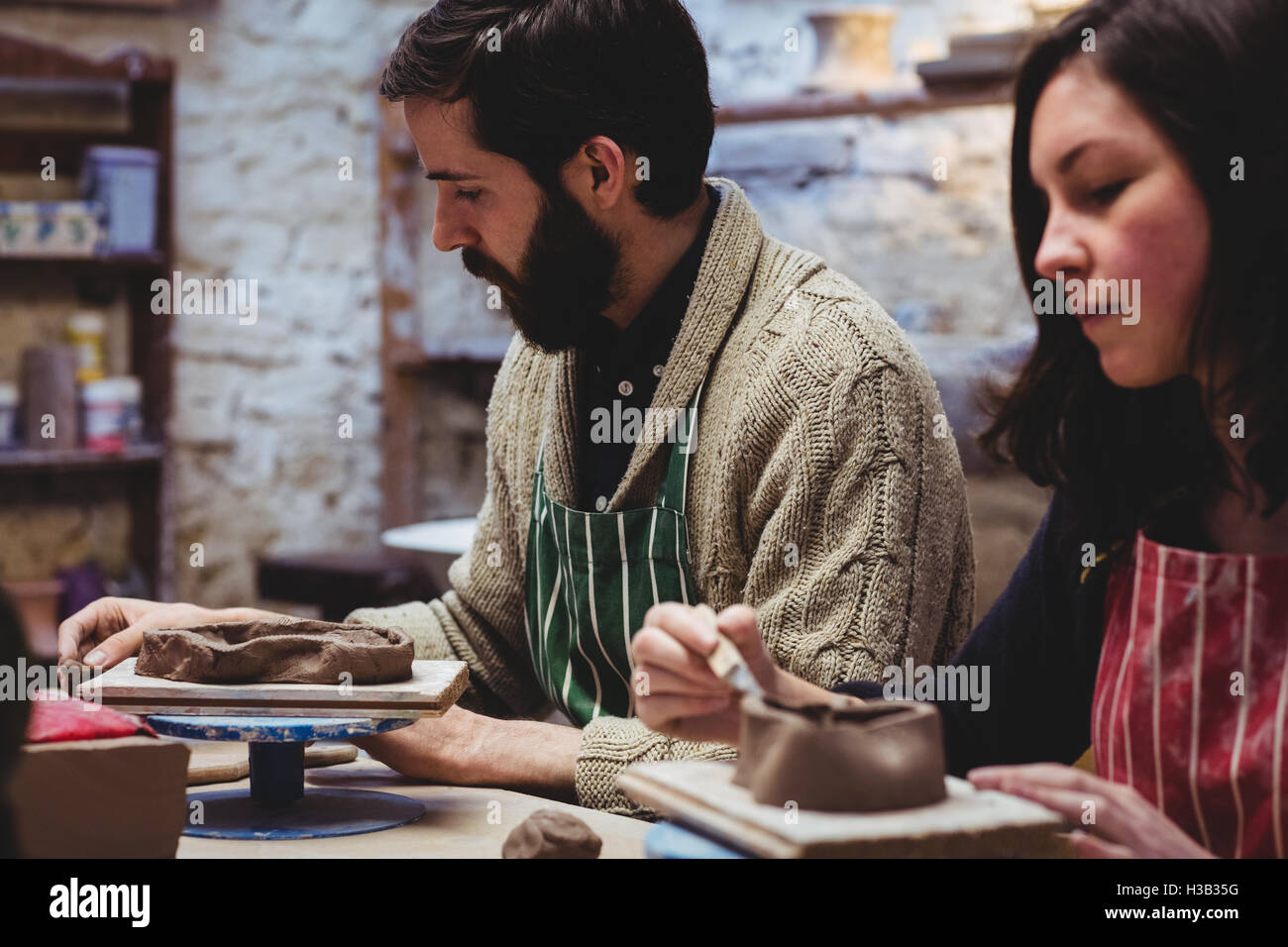 Close-up of female potter avec collègue masculin Banque D'Images