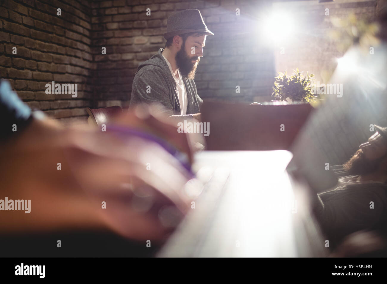 Close-up of customer typing on laptop contre l'homme au café Banque D'Images