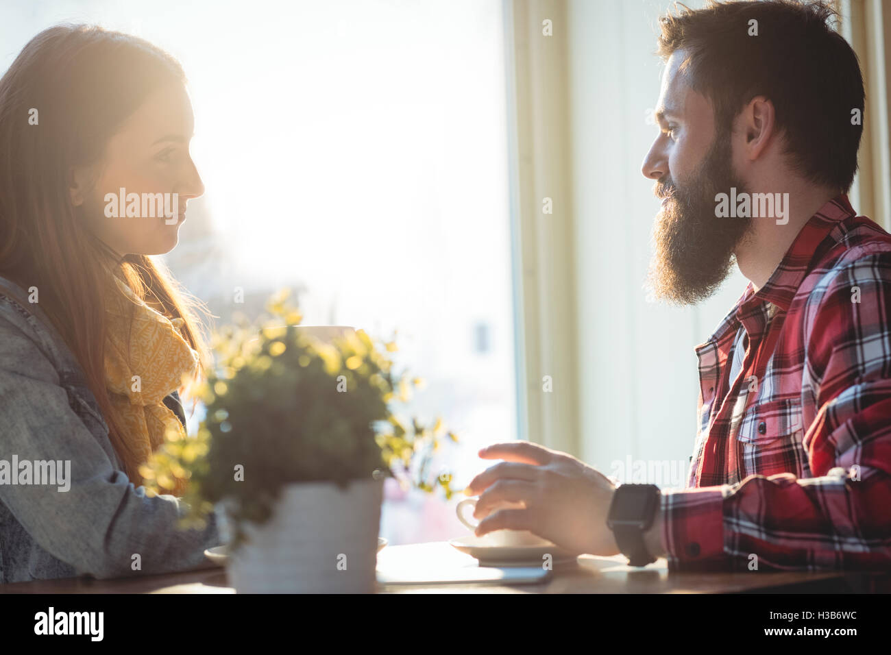 Side view of man and woman talking at cafe Banque D'Images