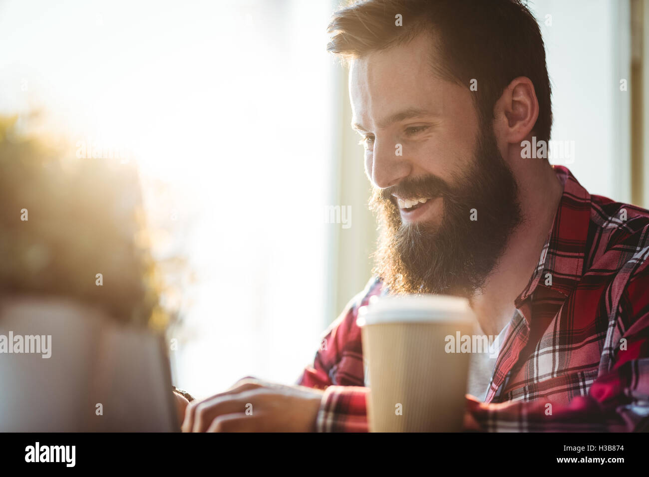 Cheerful hipster avec gobelet jetable au coffee house Banque D'Images