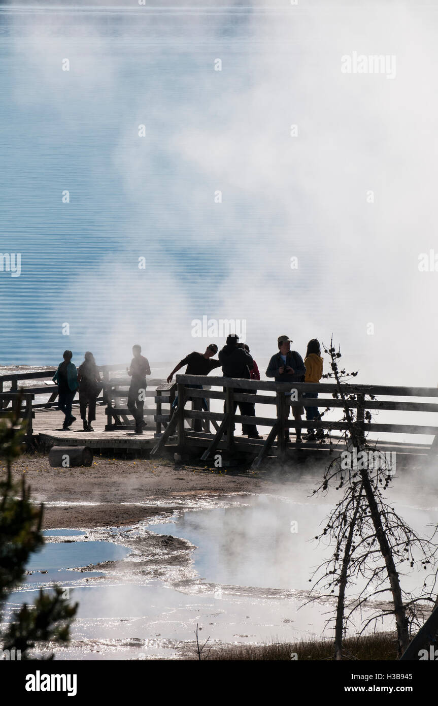 Visiteurs sur demande affichage des geysers et des piscines d'ébullition springs de West Thumb le Parc National de Yellowstone, Wyoming, USA. Banque D'Images