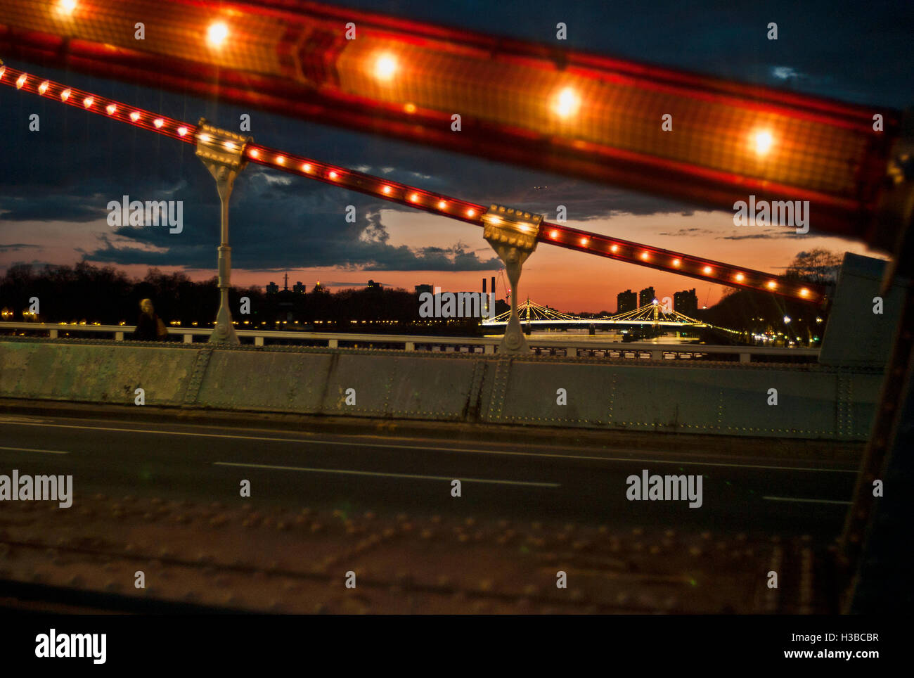 Allumé Chelsea Bridge sur la Tamise avec Albert Bridge en arrière-plan Banque D'Images