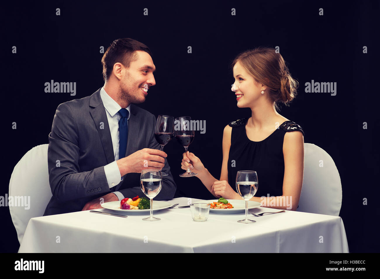 Smiling couple eating plat principal au restaurant Banque D'Images