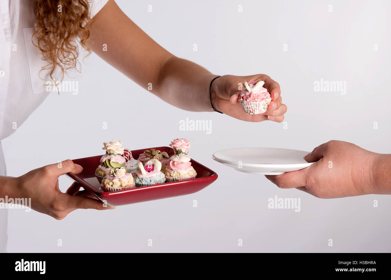 Une serveuse servant un plateau de gâteaux de fées Banque D'Images