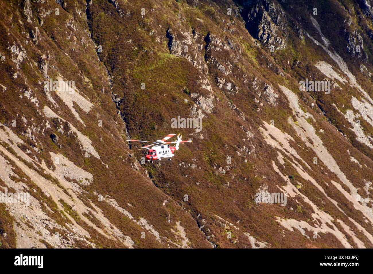 Un hélicoptère de sauvetage en montagne Cadair Idris dans le parc national de Snowdonia au Pays de Galles, Royaume-Uni Banque D'Images
