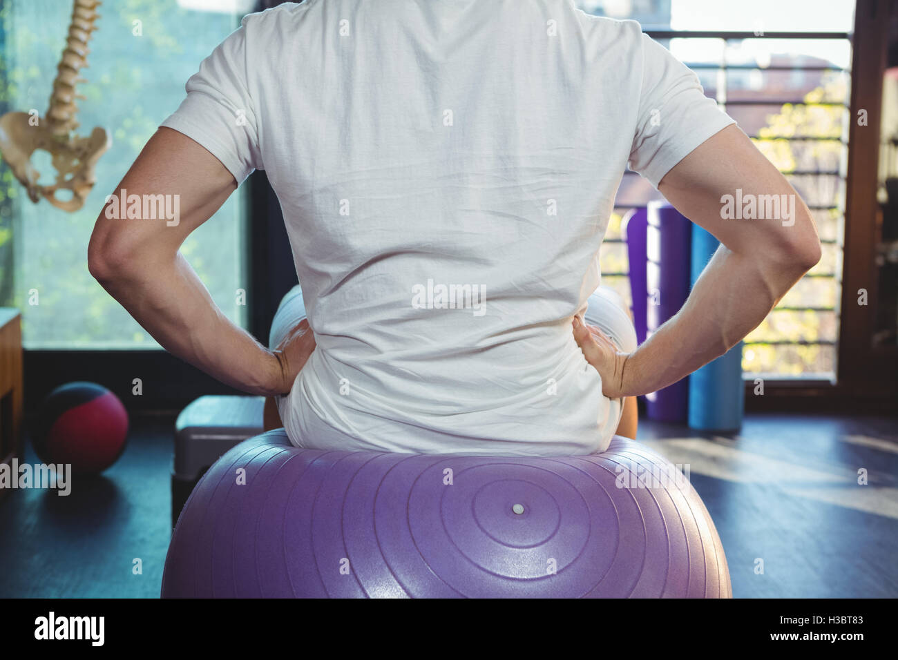 Male patient sitting on exercise ball Banque D'Images