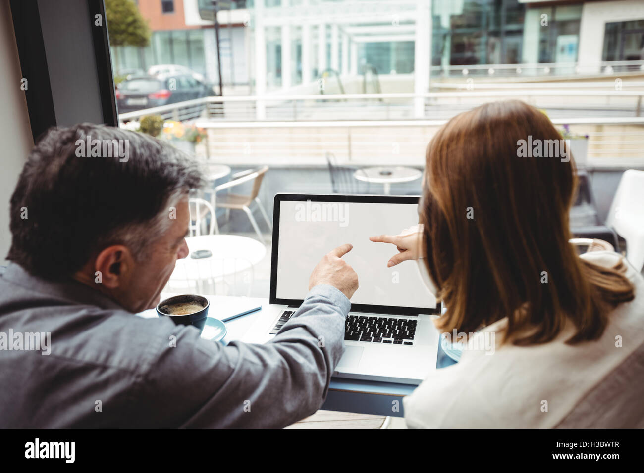 L'homme et la femme discussing over laptop Banque D'Images