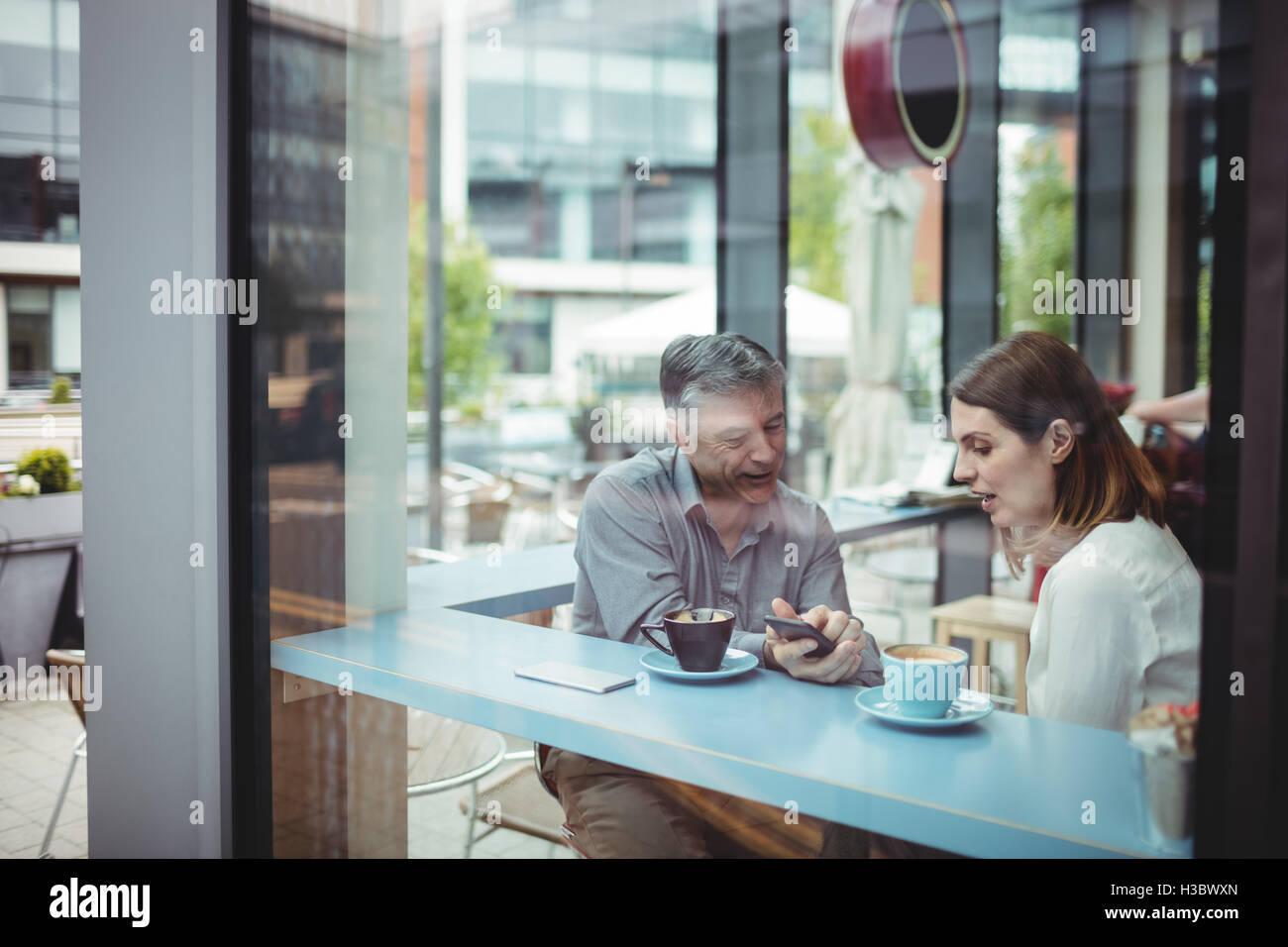 L'homme et de la femme de discuter sur téléphone mobile Banque D'Images