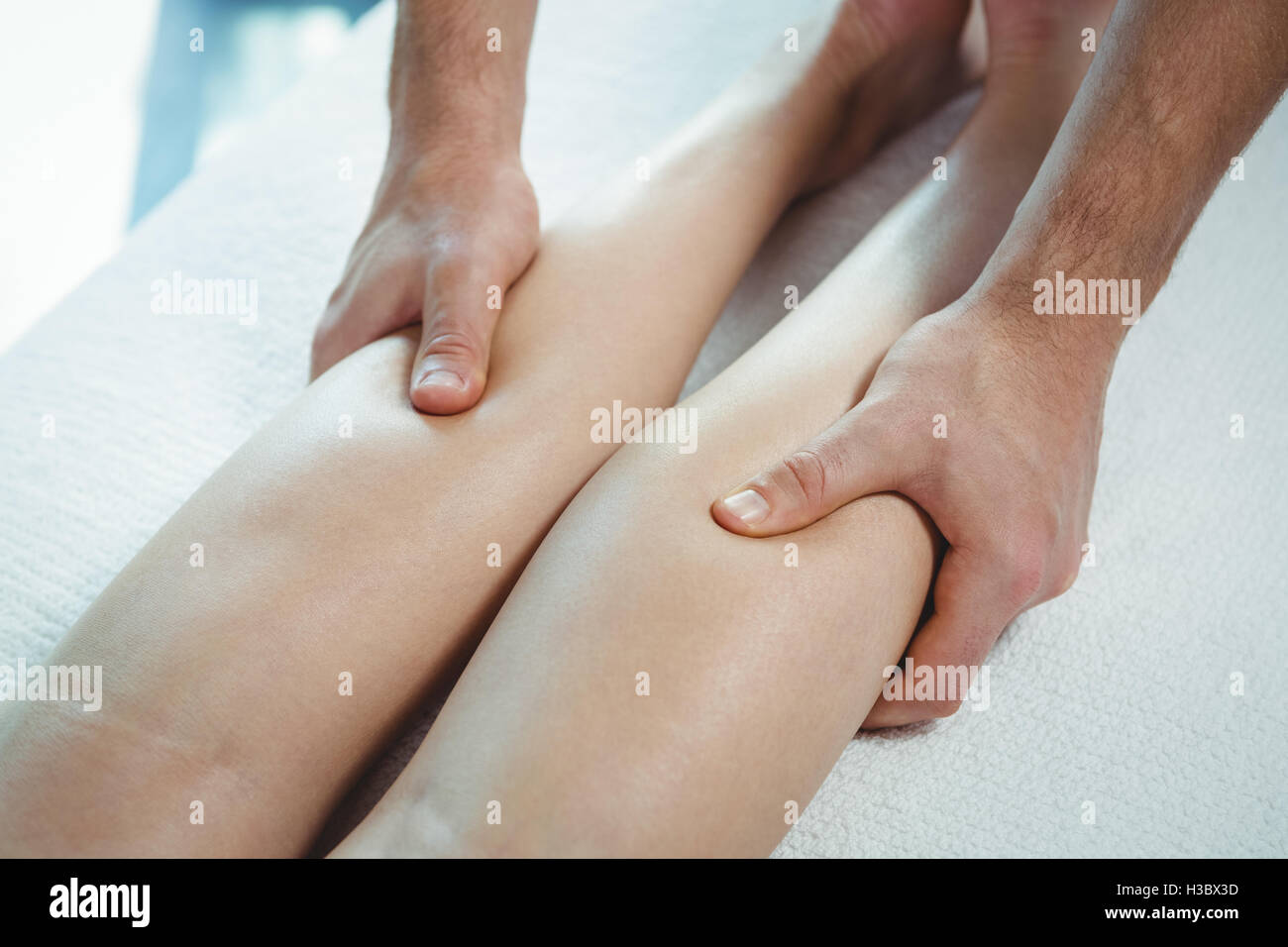 Physiothérapeute thérapie physique donnant à la jambe d'une femme Banque D'Images
