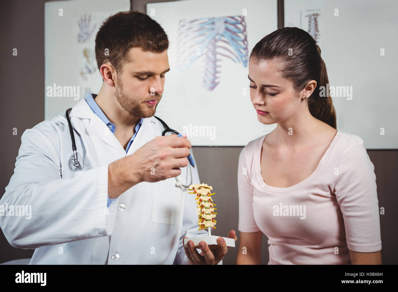 Physiothérapeute expliquant la colonne vertébrale au patient de sexe féminin Banque D'Images