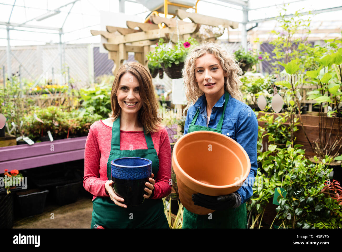 Deux femmes fleuristes holding pot Banque D'Images Deux femmes fleuristes holding pot Banque D'Images