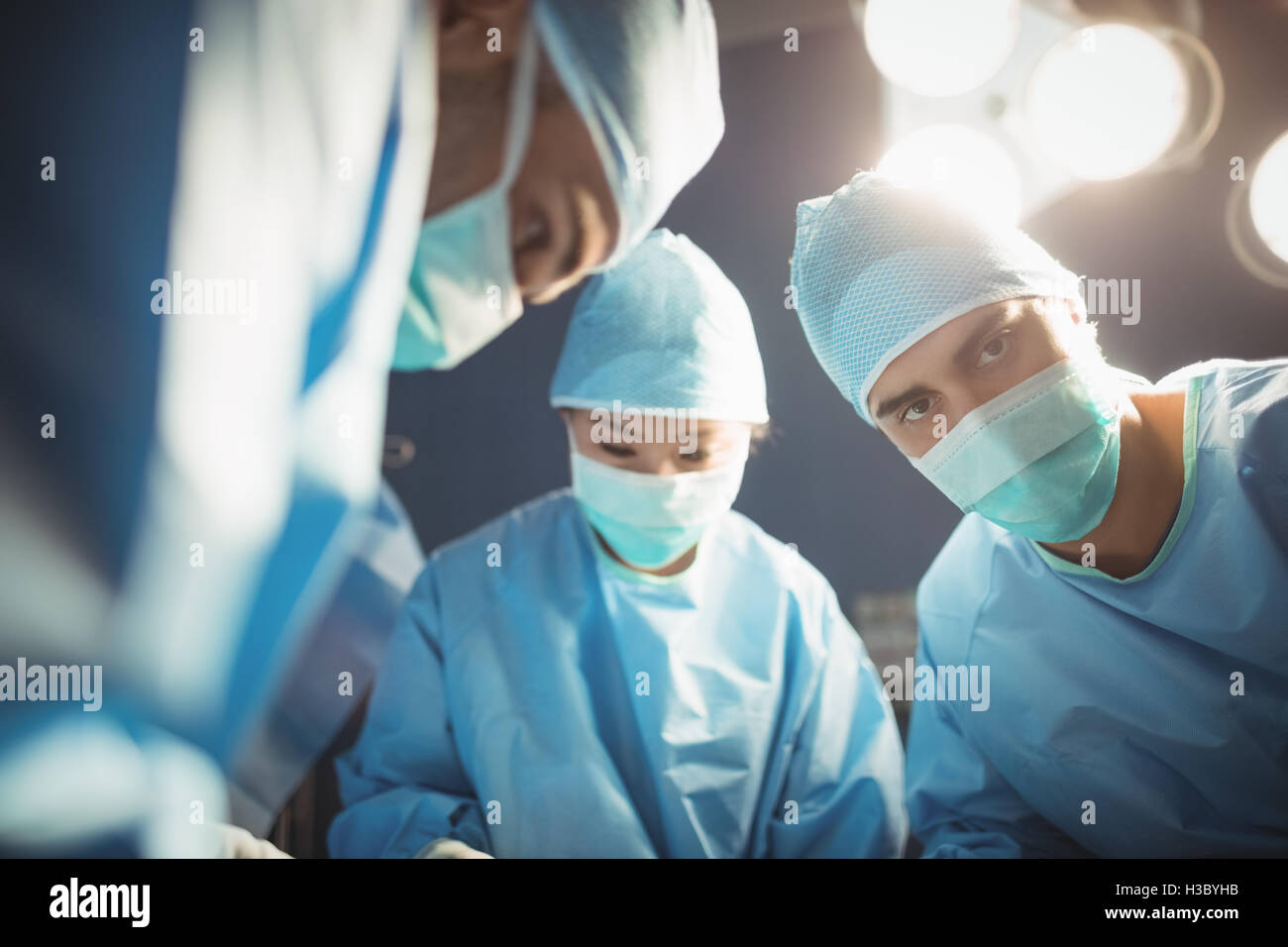 Chirurgien à la caméra tandis que ses collègues à l'exécution de l'opération Banque D'Images