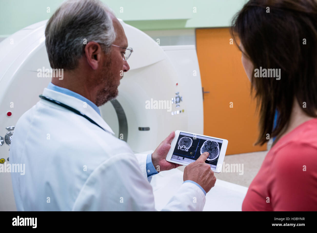 Médecin en expliquant au patient au sujet d'IRM cérébrale sur tablette Banque D'Images