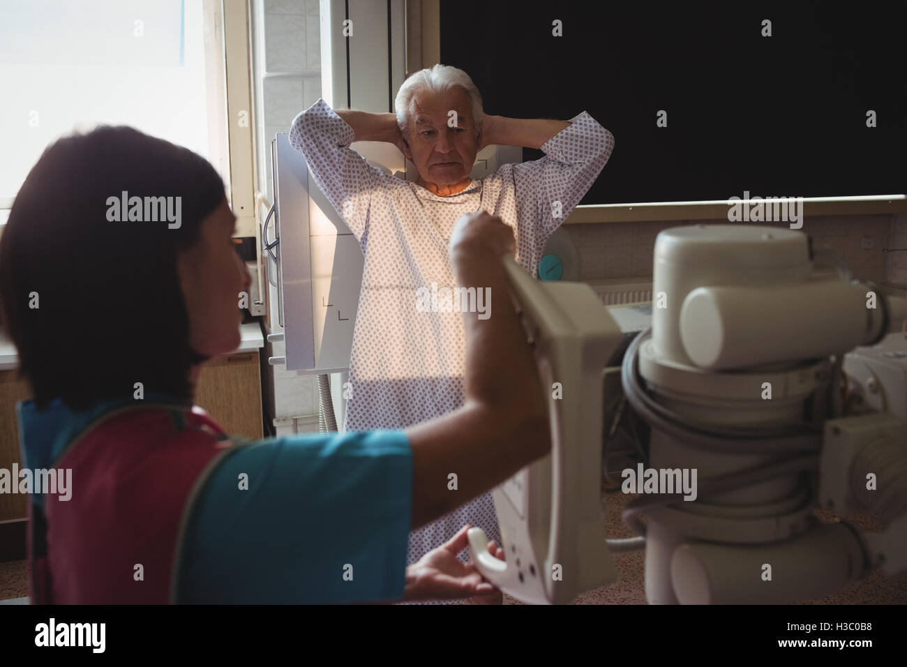 Femme médecin met en place la machine à x-ray un patients chest Banque D'Images