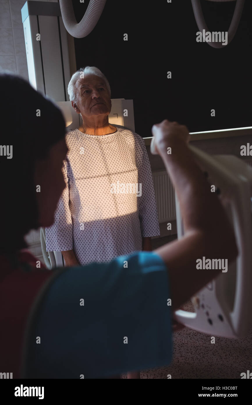 Femme médecin met en place la machine à x-ray un patients chest Banque D'Images