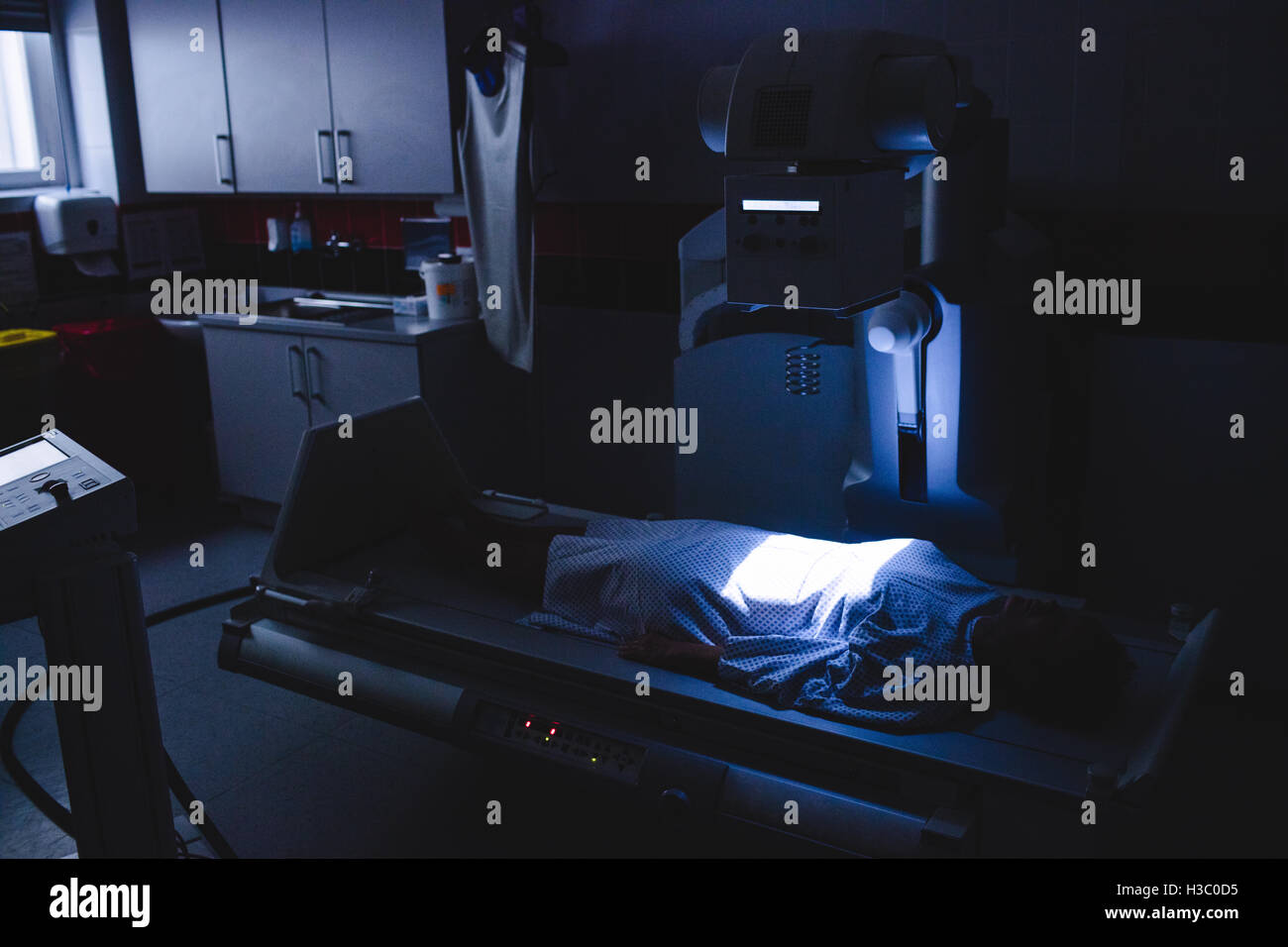 Patient couché sous machine à rayons x Banque D'Images