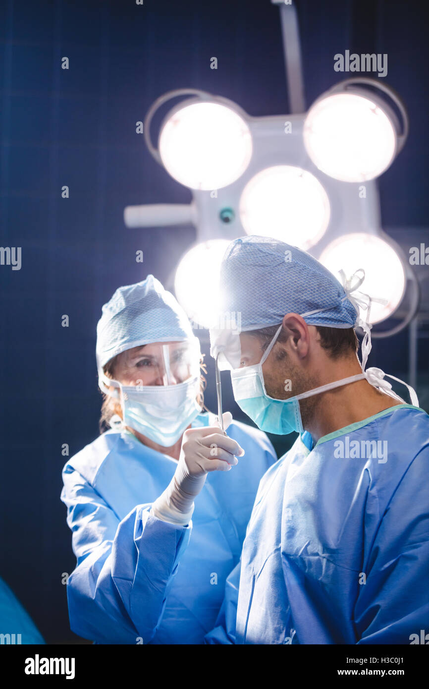 Smiling chirurgiens interagissent dans salle d'opération Banque D'Images