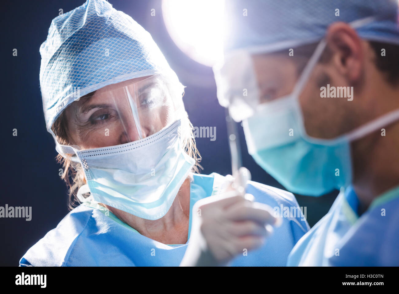 Smiling chirurgiens interagissent dans salle d'opération Banque D'Images
