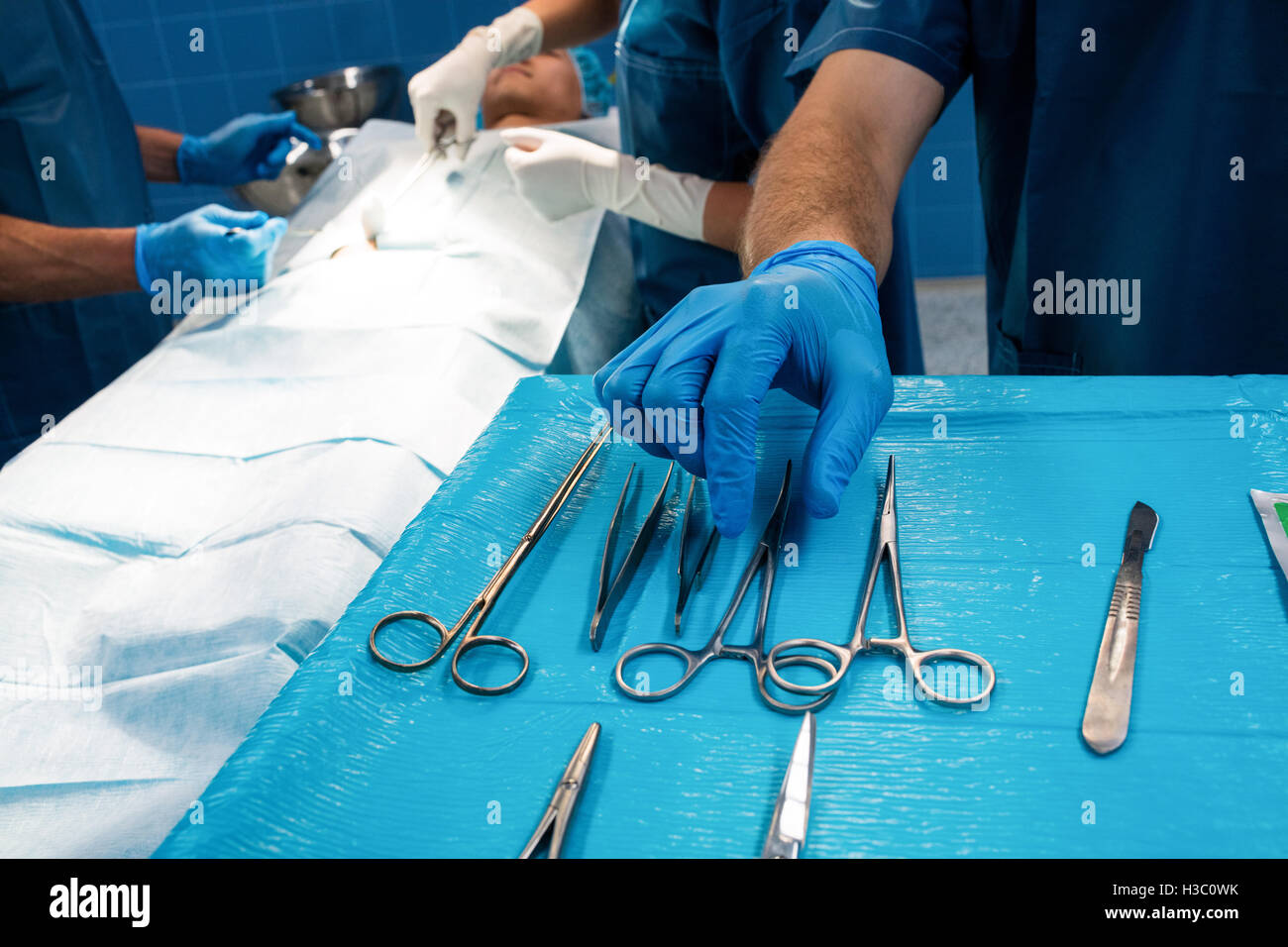 Chirurgien de prendre une paire de ciseaux à partir du bac Banque D'Images