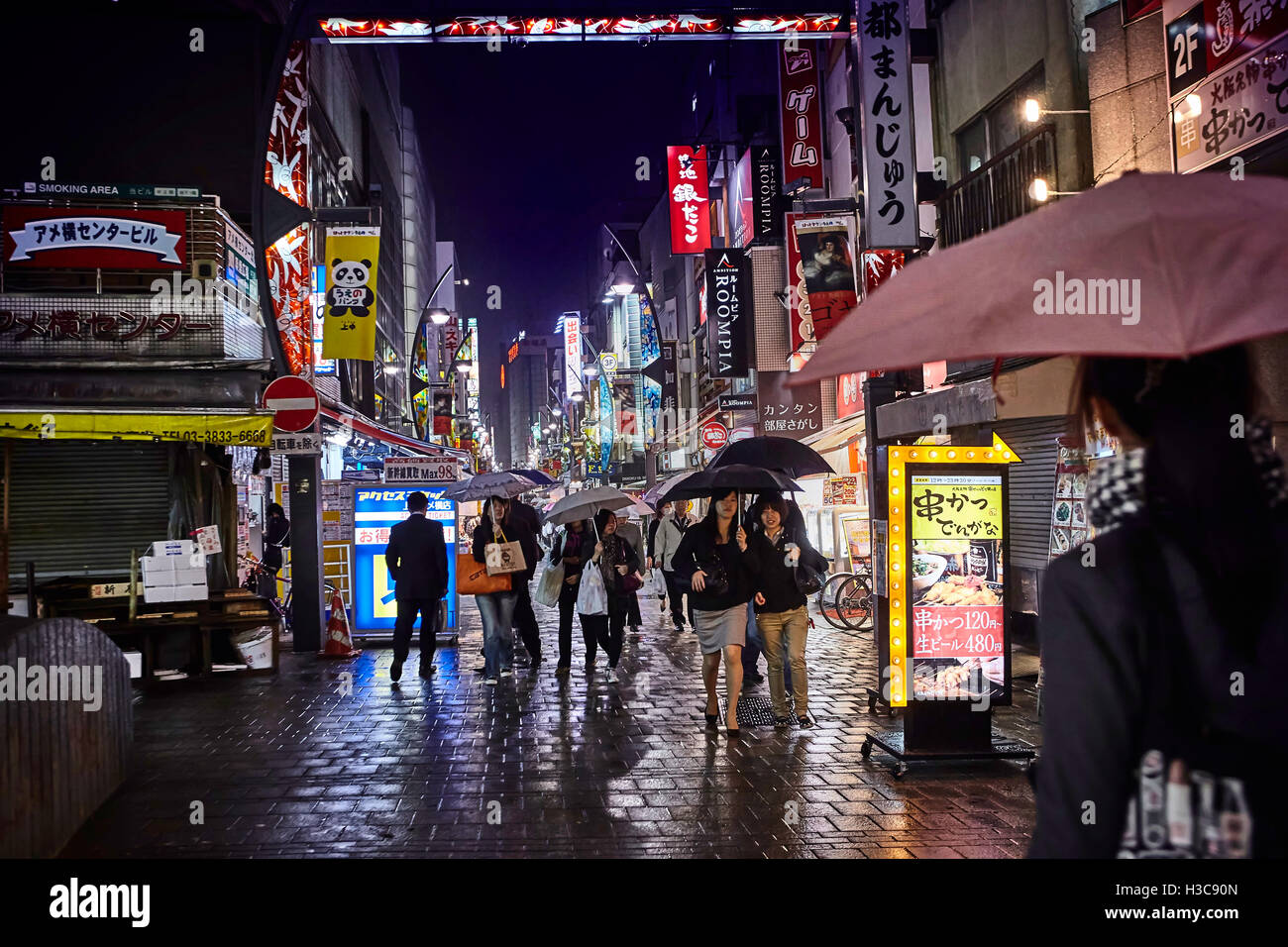 Tokyo, Japon, octobre 2011 Nuit rue après la pluie avec belle lumière du café et de la région de Tokyo shopes de Ueno station les gens marcher sous des parasols. Banque D'Images
