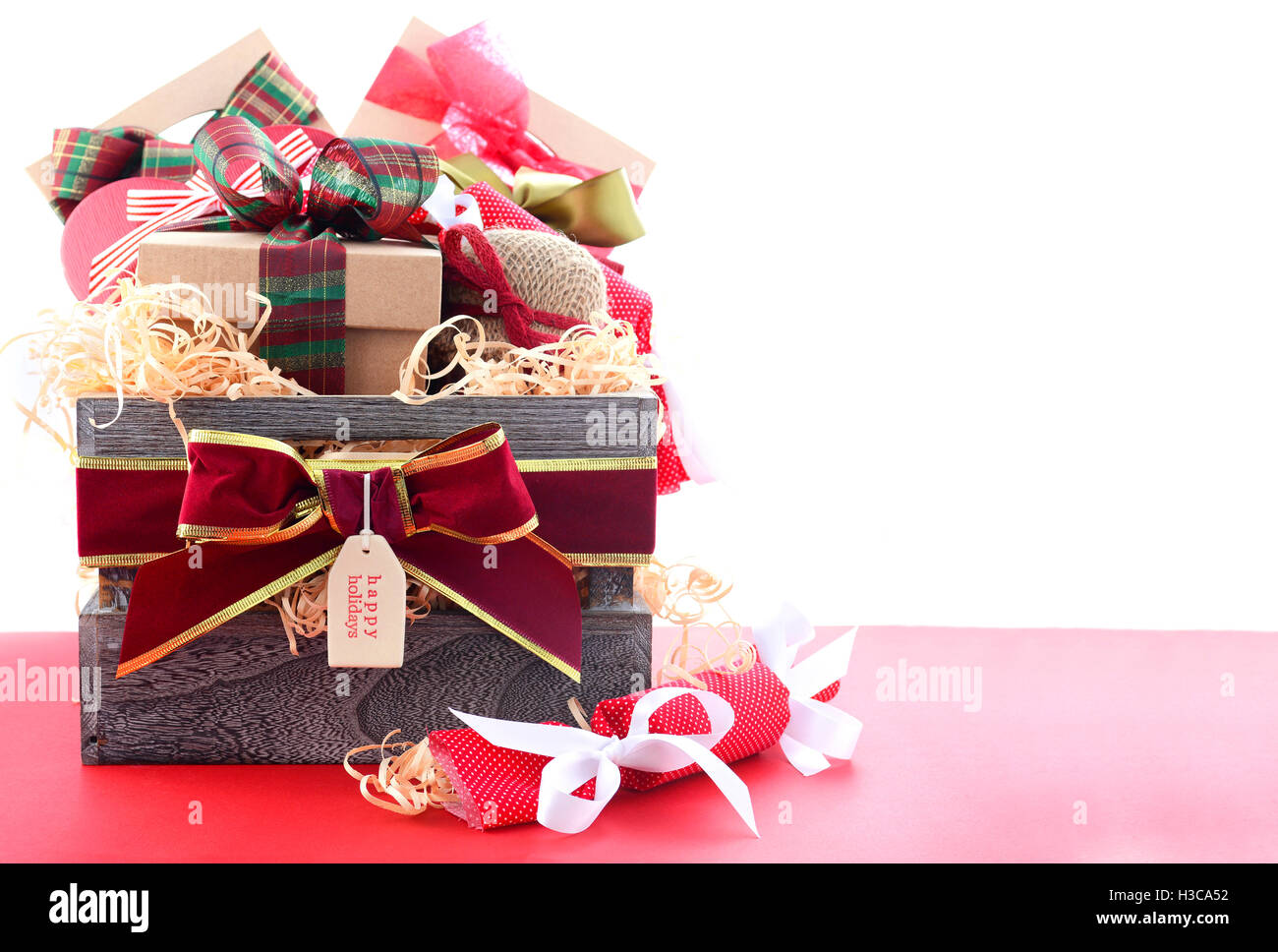 Grand panier cadeau de Noël rouge et vert traditionnel rétractable sur table en bois rouge, avec l'exemplaire de l'espace. Banque D'Images