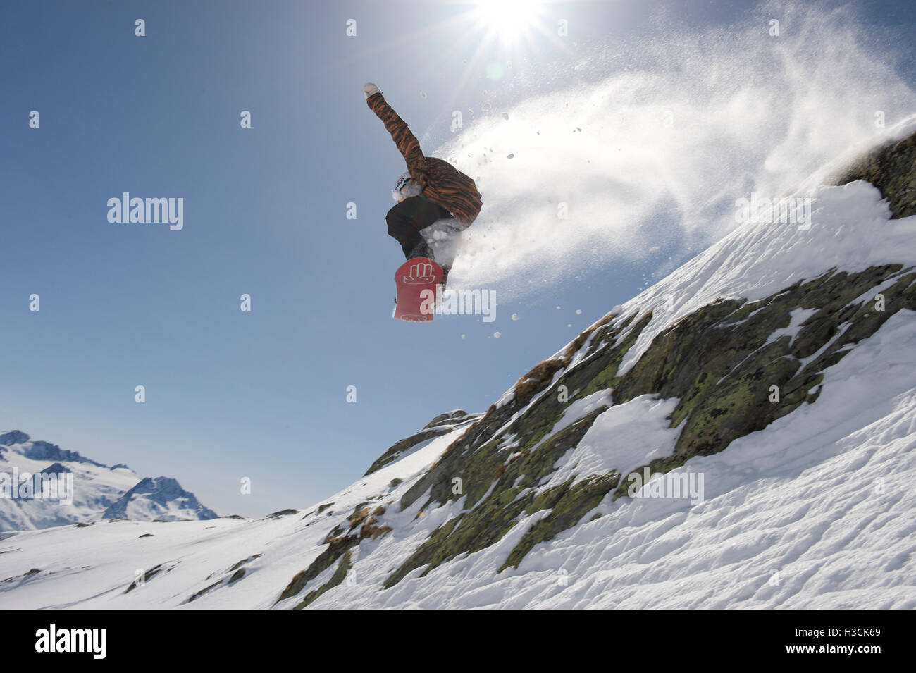 Snowboarder sautant au-dessus d'une falaise dans la station de ski Disentis 3000 Banque D'Images