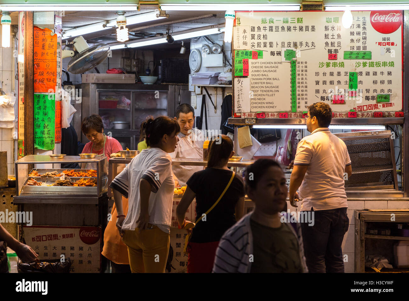 Des gens devant un street food au coin de Prat Ave et Hart Ave dans Tsim Sha Tsui, Kowloon, Hong Kong, Chine, la nuit. Banque D'Images