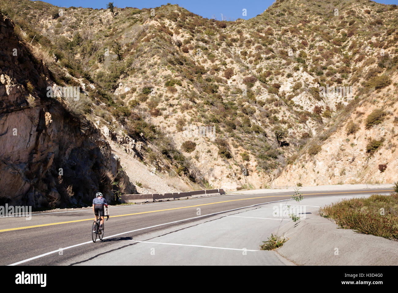 Vélo homme sur la route par majestic mountain Banque D'Images