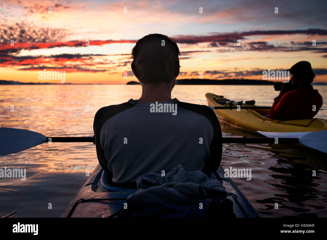 Vue arrière de l'homme kayak au détroit de Géorgie pendant le coucher du soleil Banque D'Images