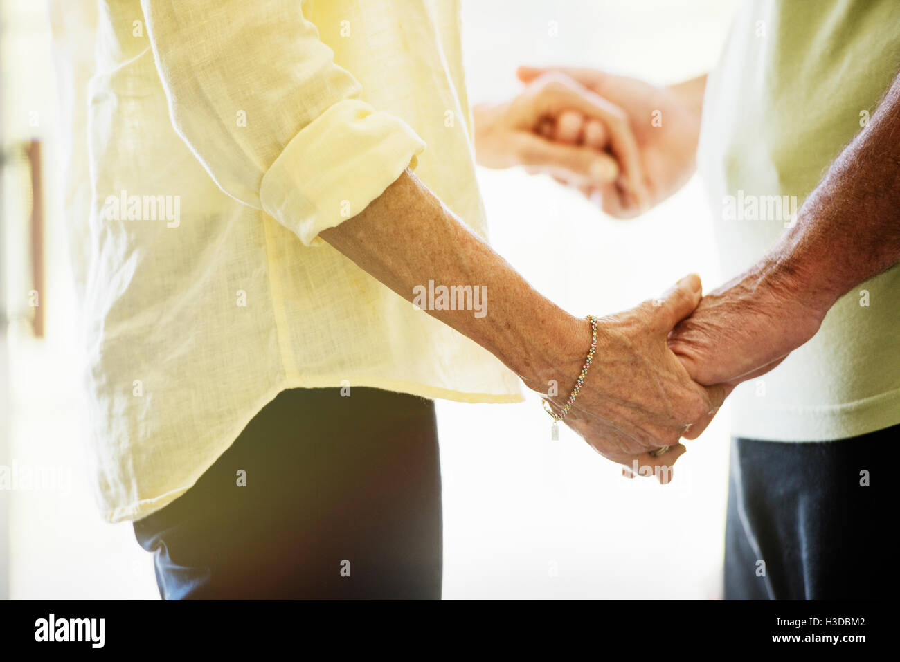 Close up of a senior couple holding hands, en face de l'autre. Banque D'Images