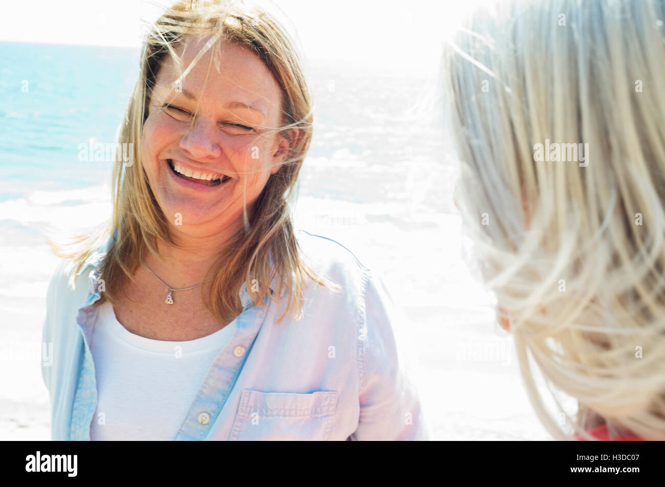 Smiling blonde femmes mûres debout près de l'océan. Banque D'Images