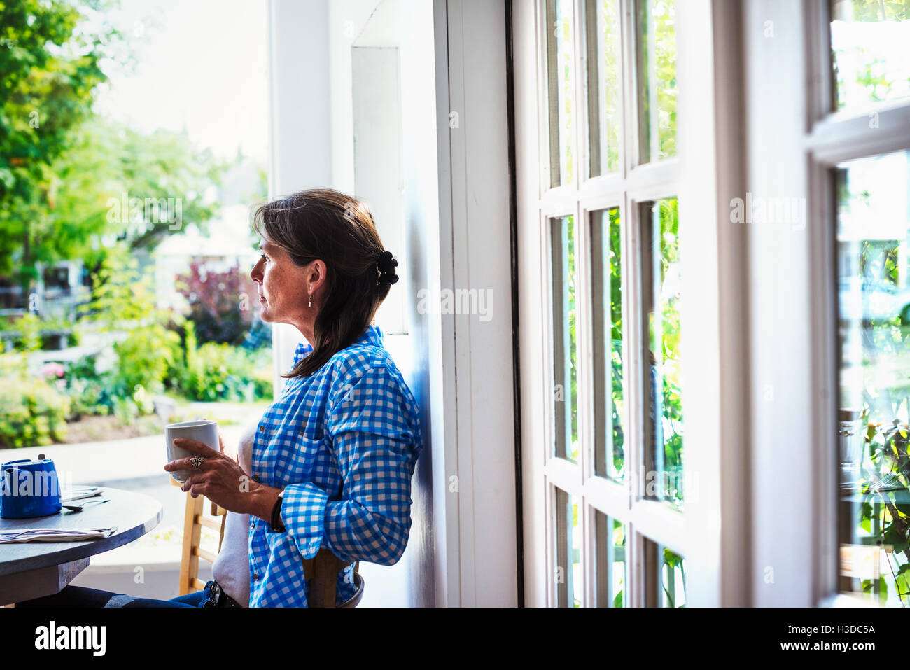 Une femme à l'extérieur tenant une tasse de café. Banque D'Images