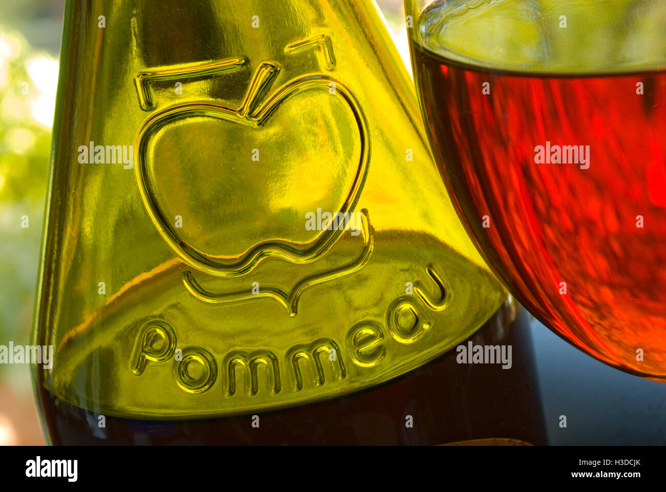 Fermer la vue sur la bouteille et verre de Pommeau de Normandie faite avec du jus de pomme et Calvados en terrasse situation le jardin Banque D'Images