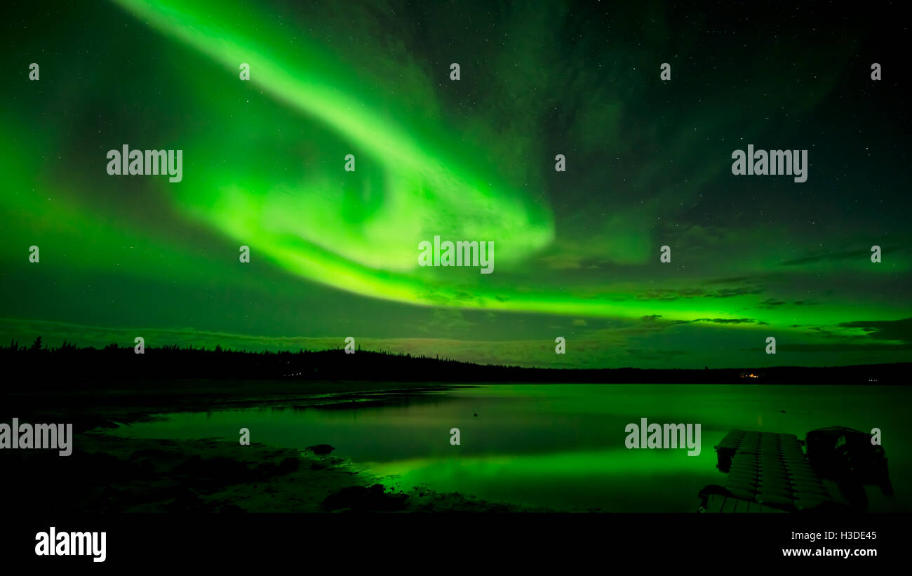 Spinning Northern Lights - Bandes de bright northern lights spinning à travers le ciel étoilé au-dessus d'un lac. Banque D'Images