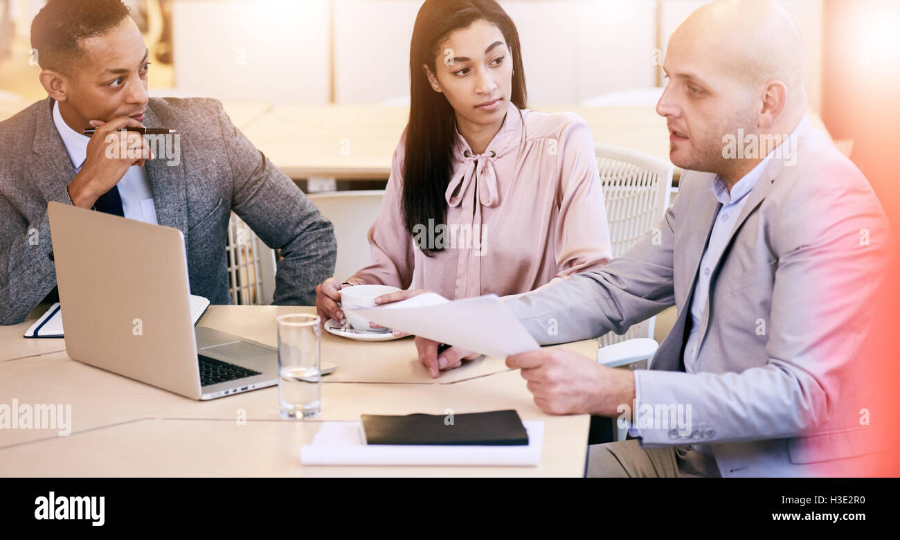 Trois cadres d'affaires de la communication au cours de séance dans la salle de conférence Banque D'Images