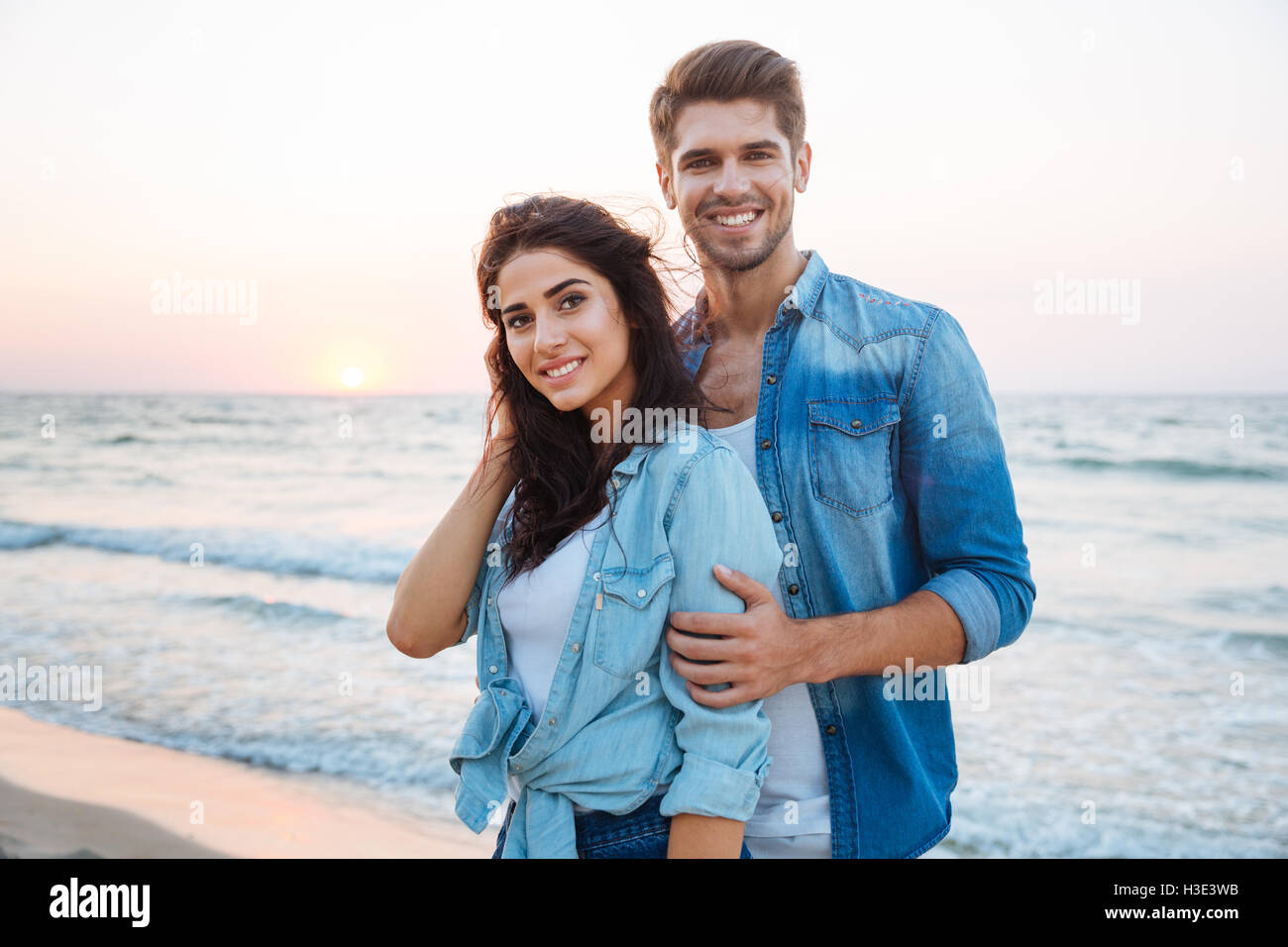 Portrait de beau jeune couple standing and smiling sur la plage Banque D'Images