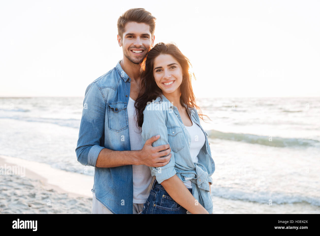 Smiling young couple in love debout à la plage Banque D'Images