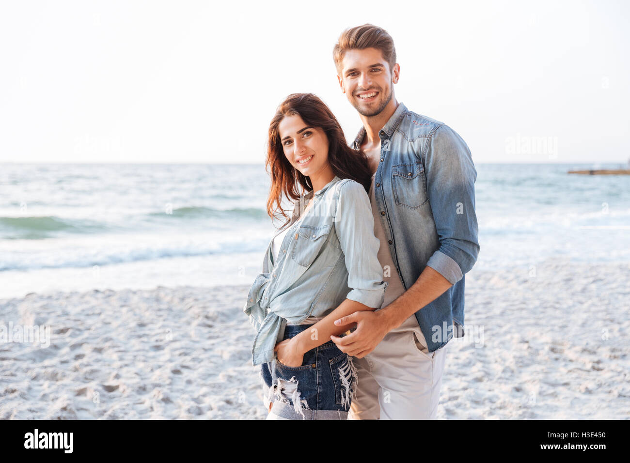 Beau jeune couple debout sur la plage Banque D'Images