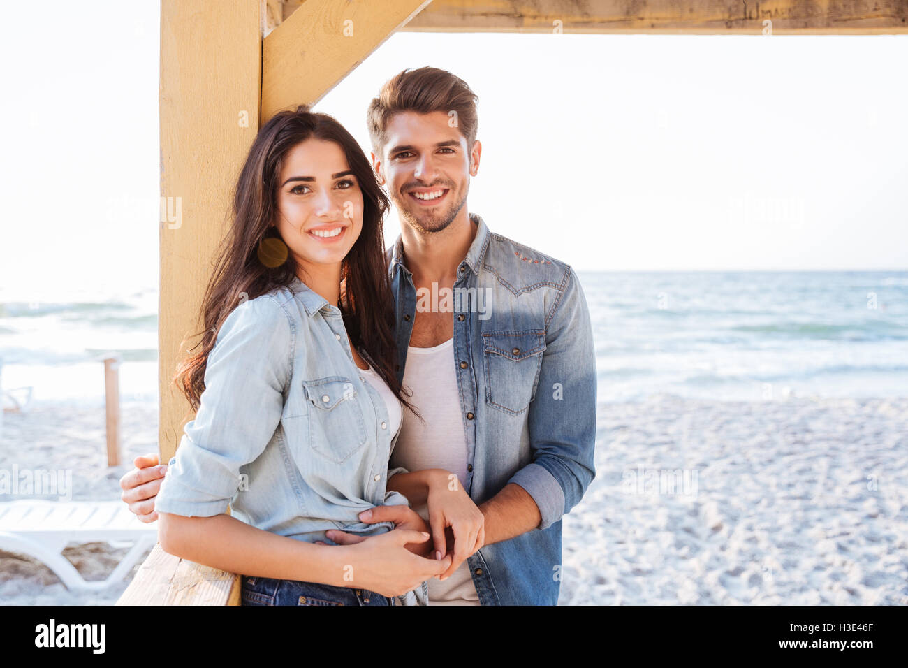 Young smiling couple amoureux se tenant ensemble à la plage Banque D'Images