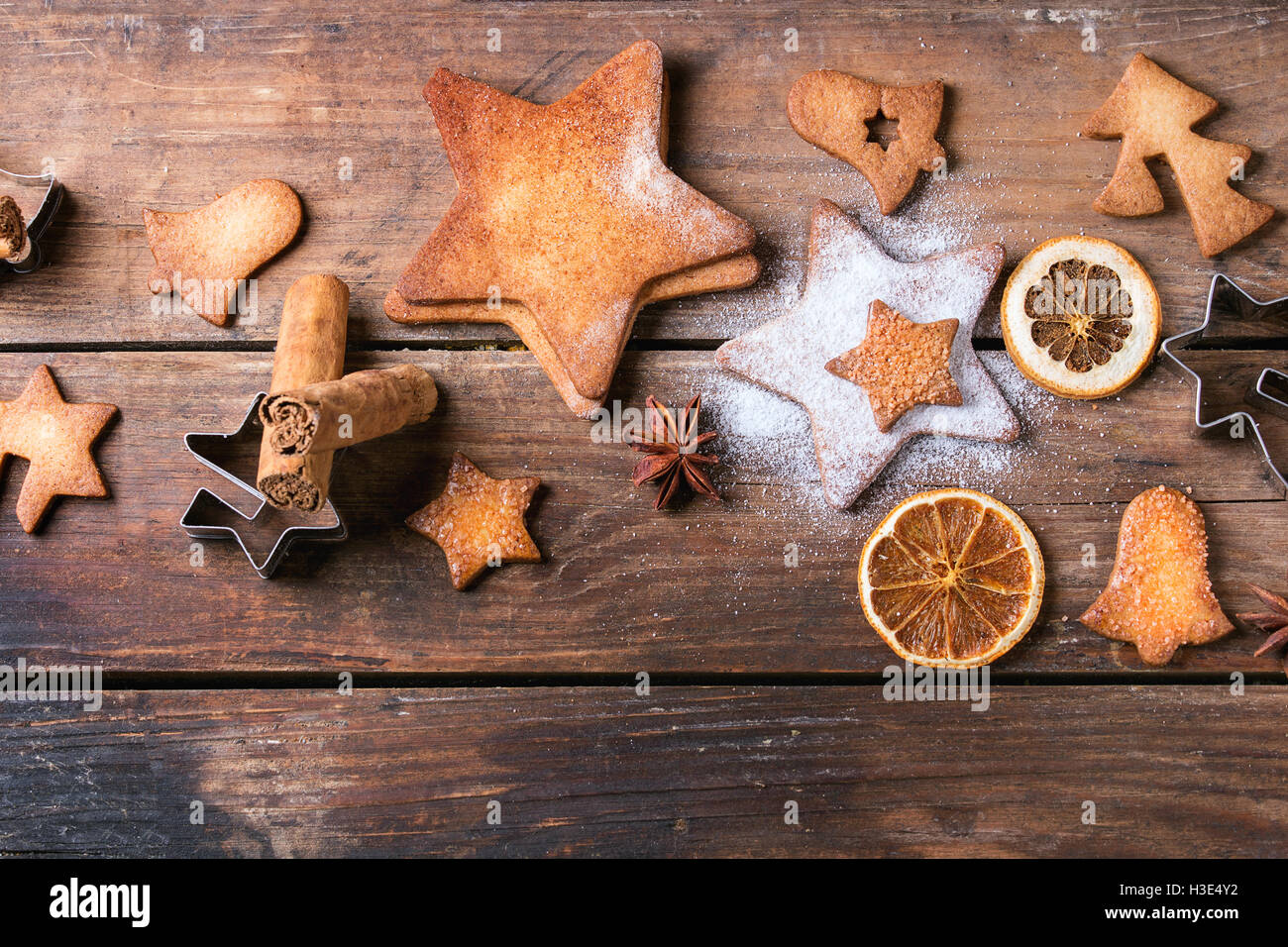 Des sablés de Noël star shape les biscuits sucrés avec du sucre en poudre de taille différente, de cannelle et d'un emporte-pièce sur le vieux bois Banque D'Images