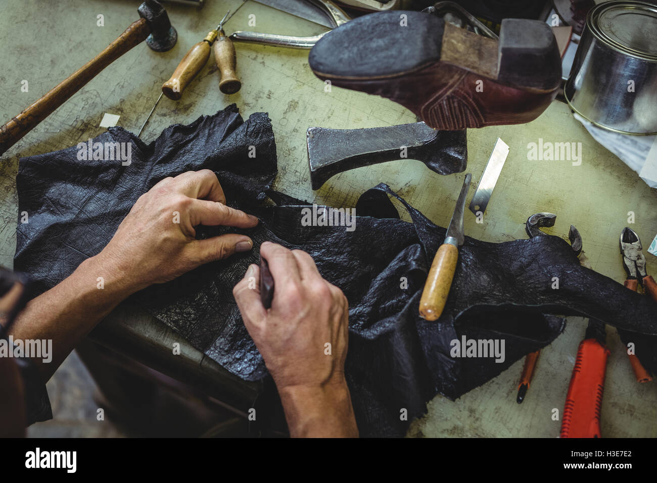 Shoemaker couper un morceau de matériau Banque D'Images