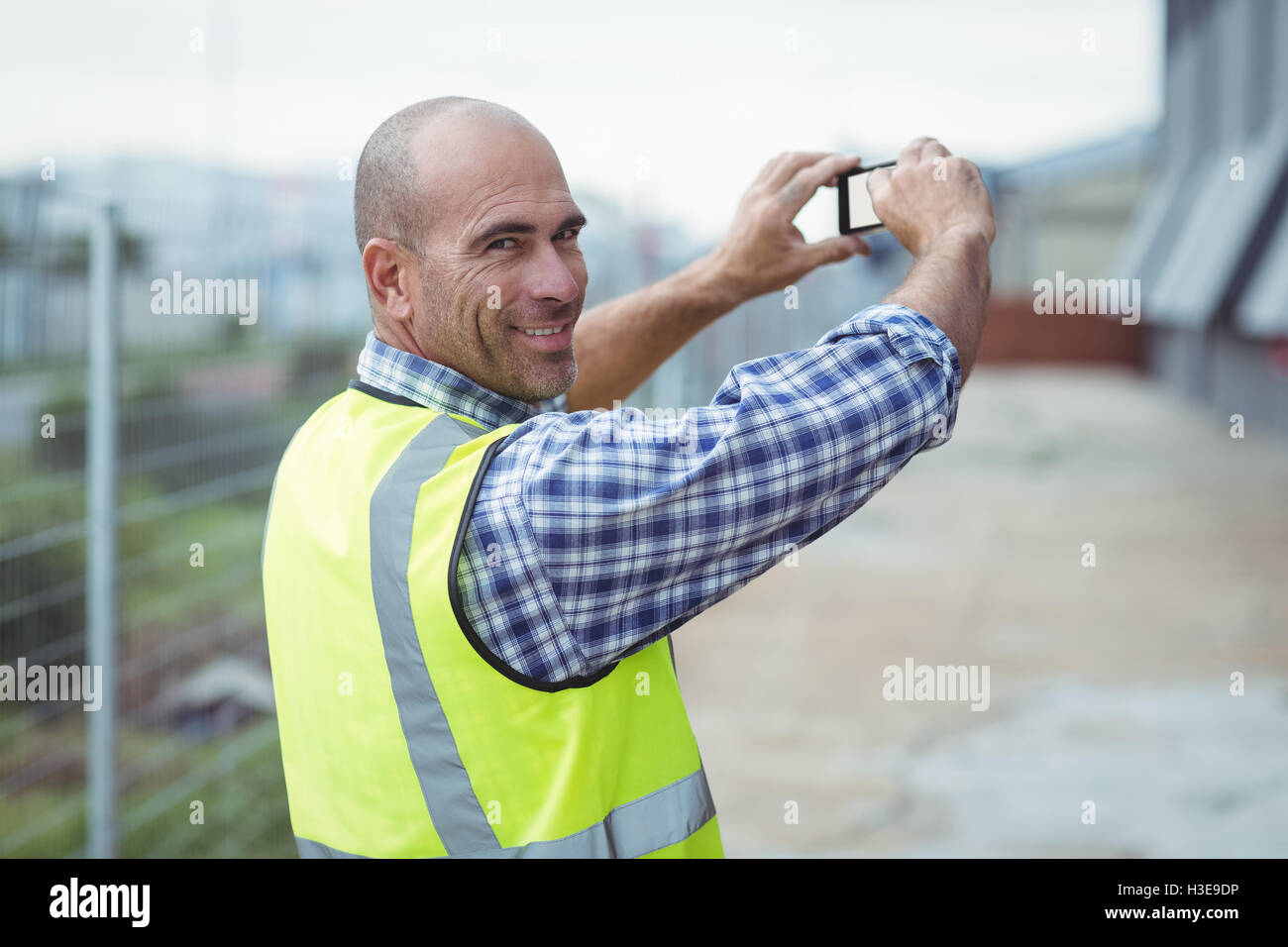 Travailleur de la construction à photographier avec un téléphone mobile Banque D'Images