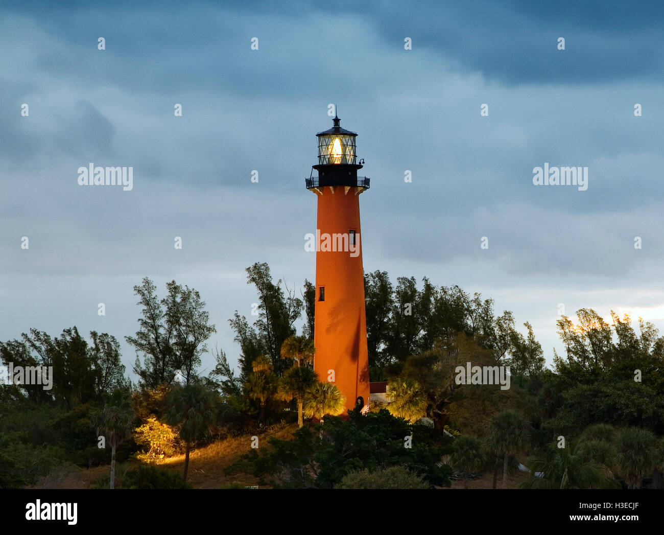 La tour de briques orange du phare de Jupiter , Floride, brille encore sur la mer alors que l'aube se lève sur un matin nuageux. Banque D'Images