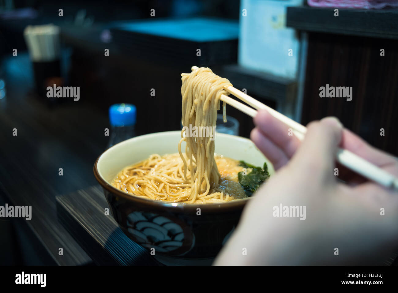 Utiliser la main prendre une baguette de nouilles ramen japonais. Banque D'Images